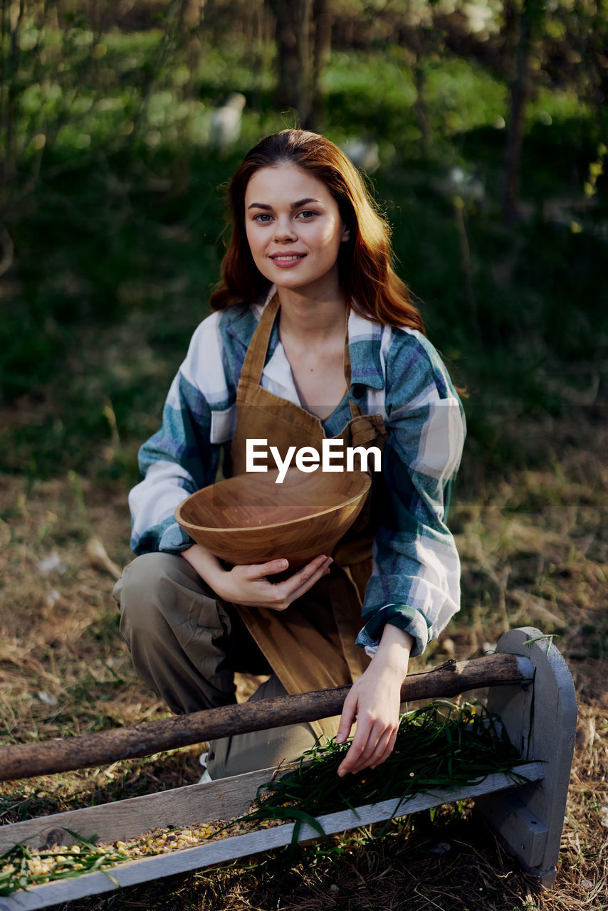 Portrait of young woman sitting in garden