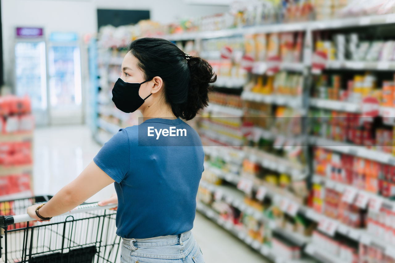 YOUNG WOMAN STANDING AT STORE