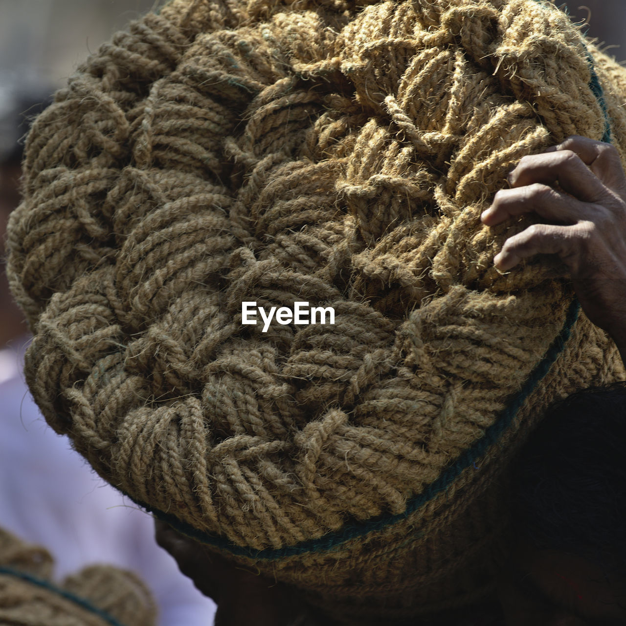 Cropped hand of man carrying rope