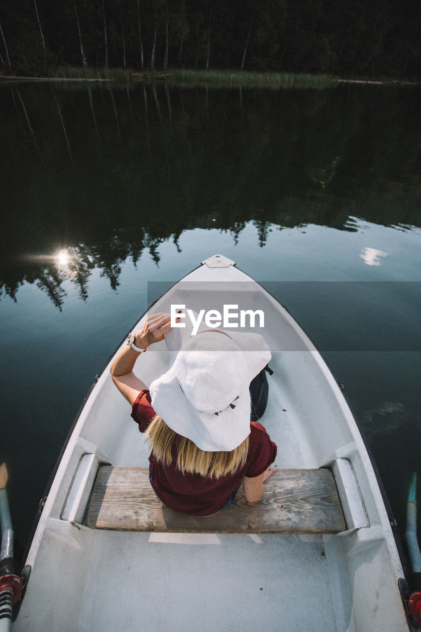 High angle view of woman sitting in boat on lake