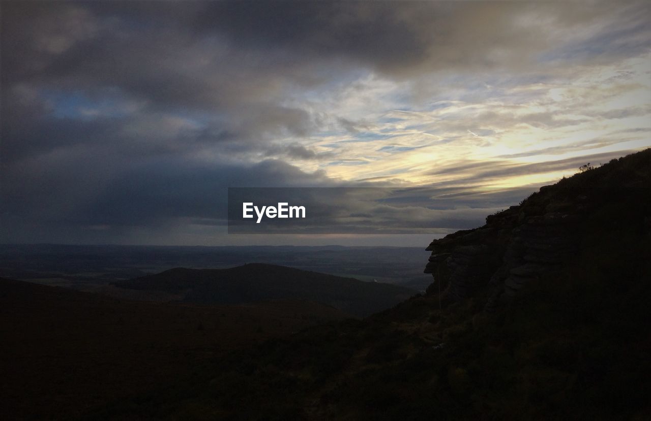 VIEW OF LANDSCAPE AGAINST CLOUDY SKY DURING SUNSET