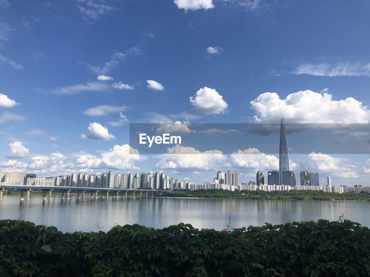 SCENIC VIEW OF RIVER AMIDST BUILDINGS AGAINST SKY