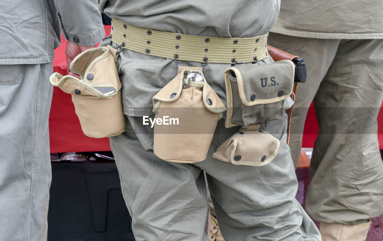 A soldier sports a belt with important tools hanging from it for military use in the desert