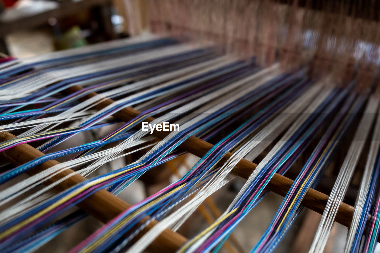 Close-up of thread in hand loom at factory