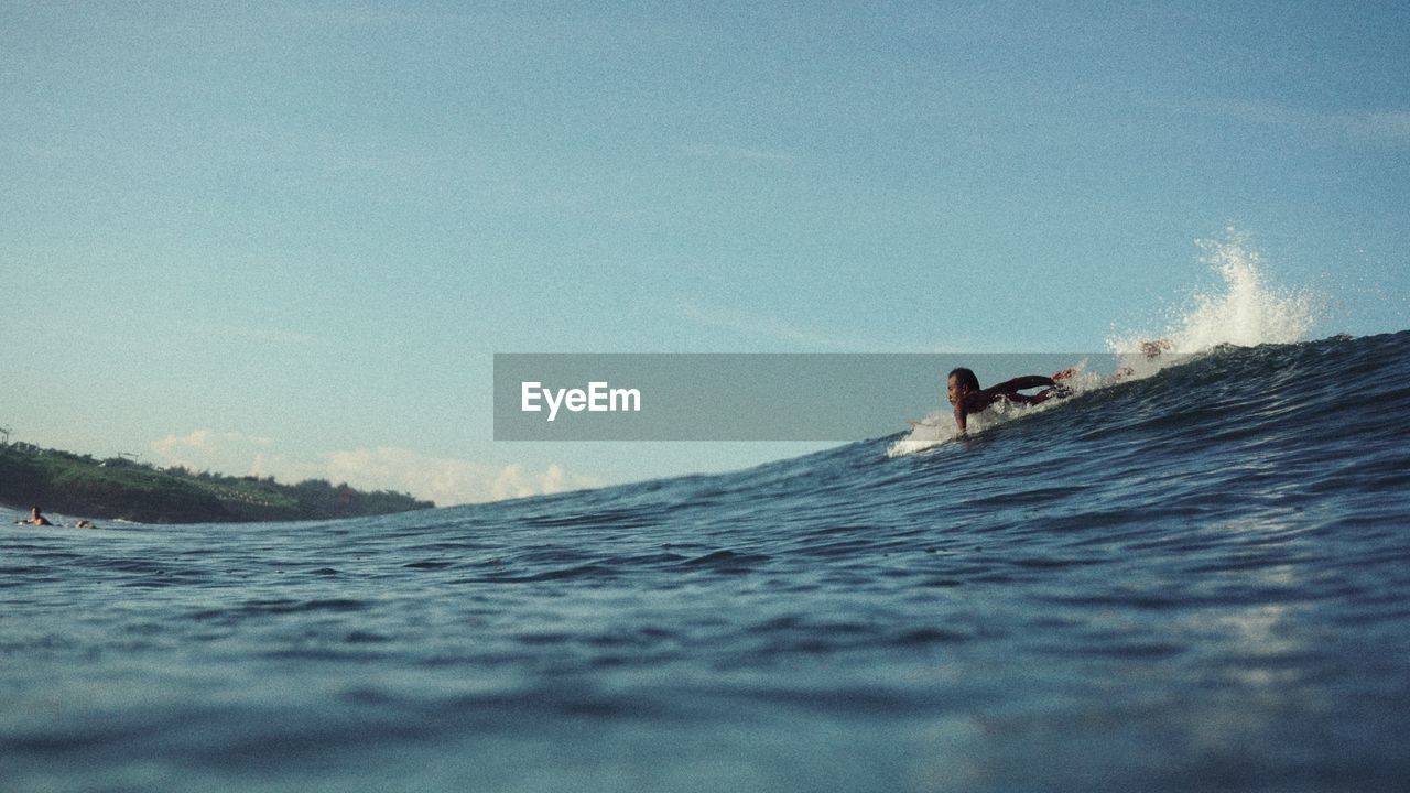 Man swimming in sea against sky