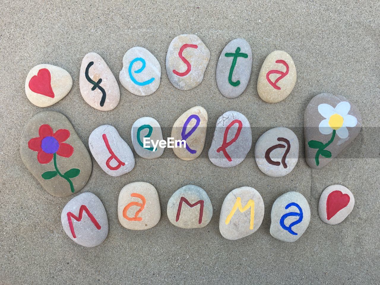 High angle view of multi colored pebbles with text at beach