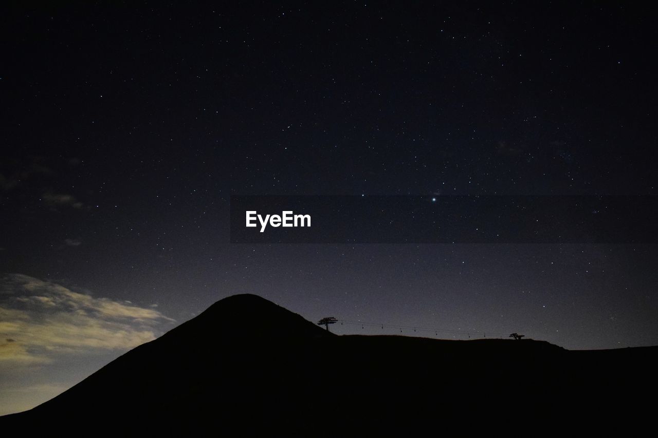 Low angle view of silhouette mountain against sky at night