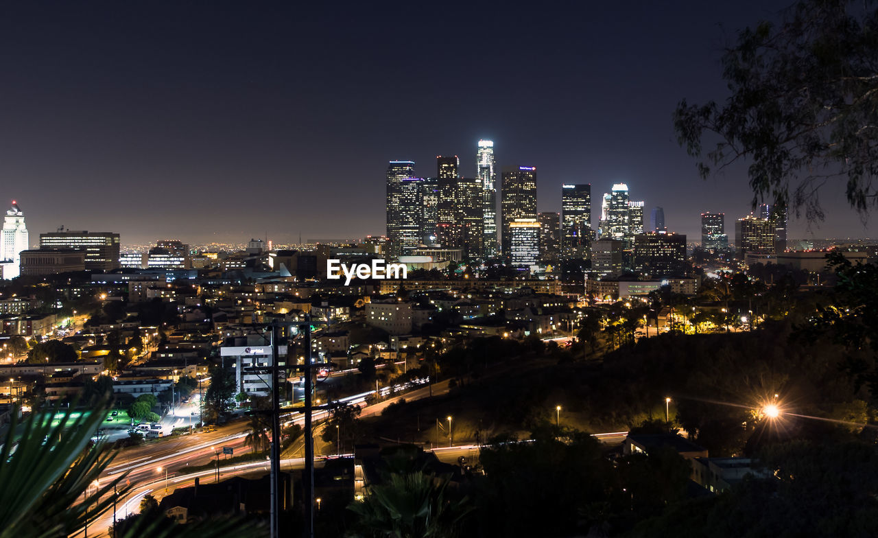 Illuminated cityscape against sky at night