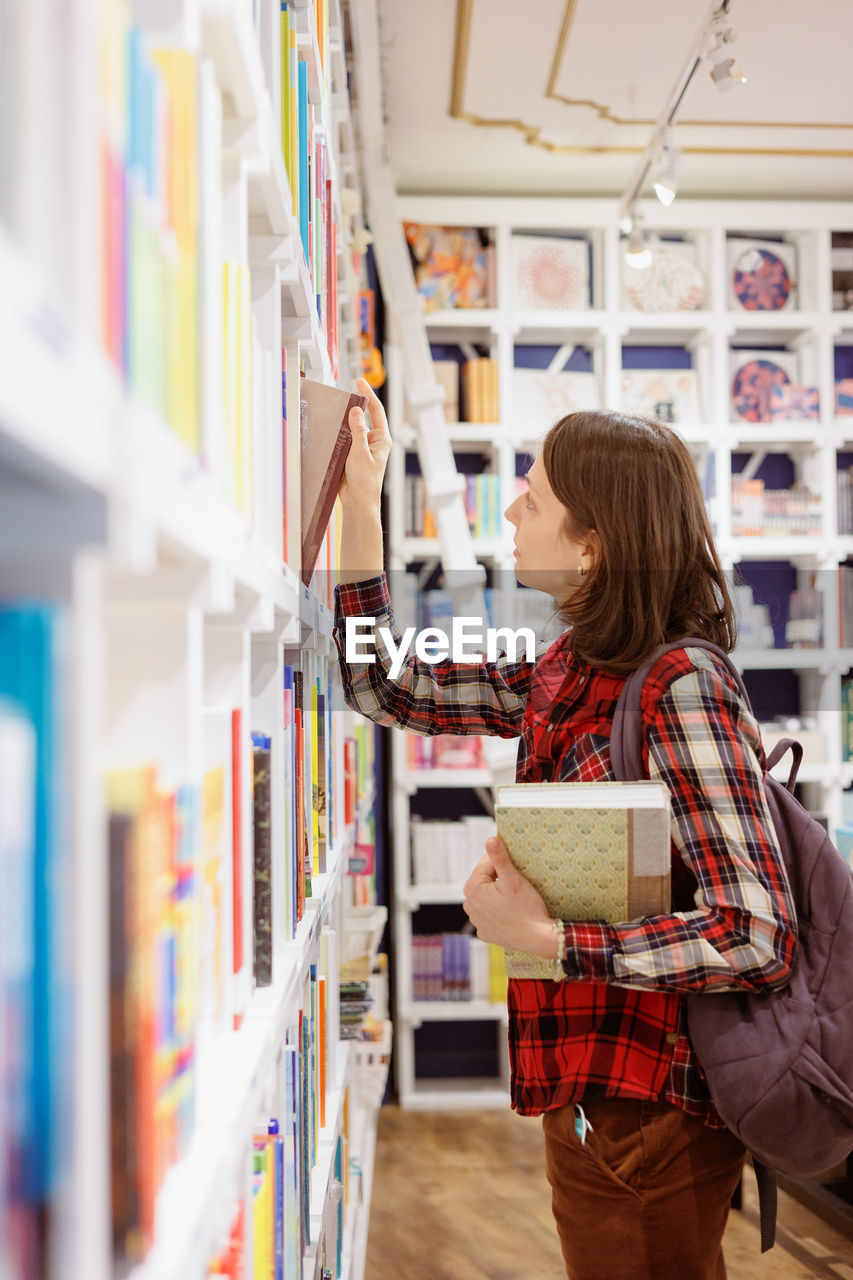 portrait of young woman standing at library