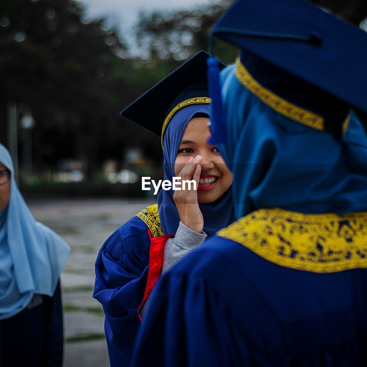 Smiling university students in graduation gowns