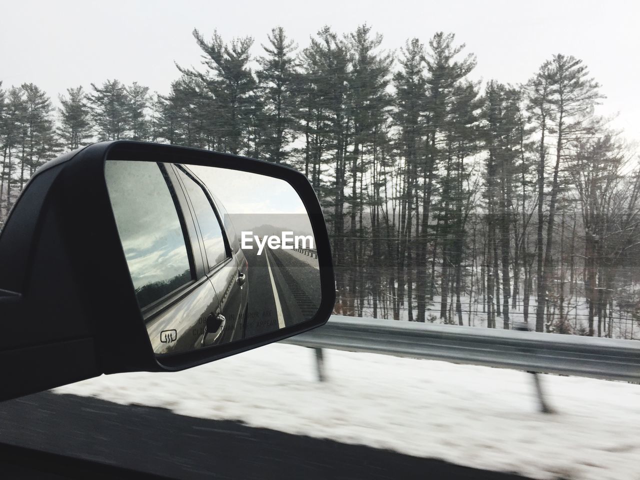 CLOSE-UP OF SIDE-VIEW MIRROR AGAINST SKY