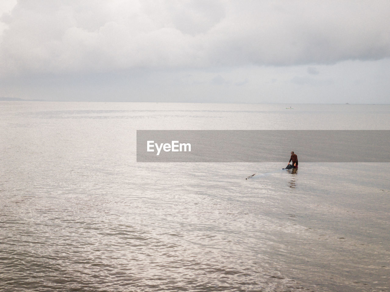 MAN SURFING IN SEA AGAINST SKY