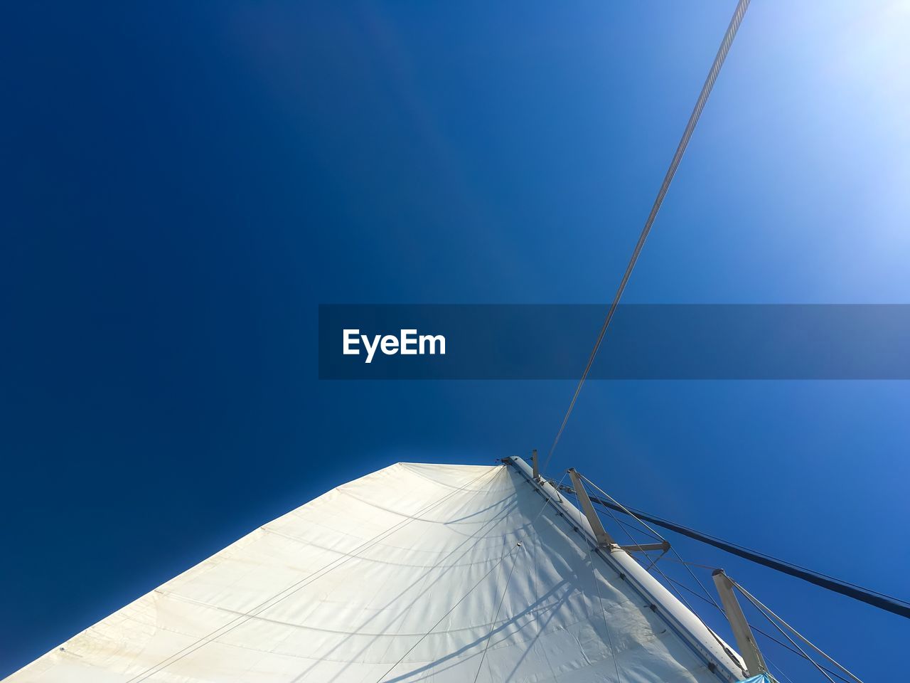 Mast and canvas of sailboat against sky