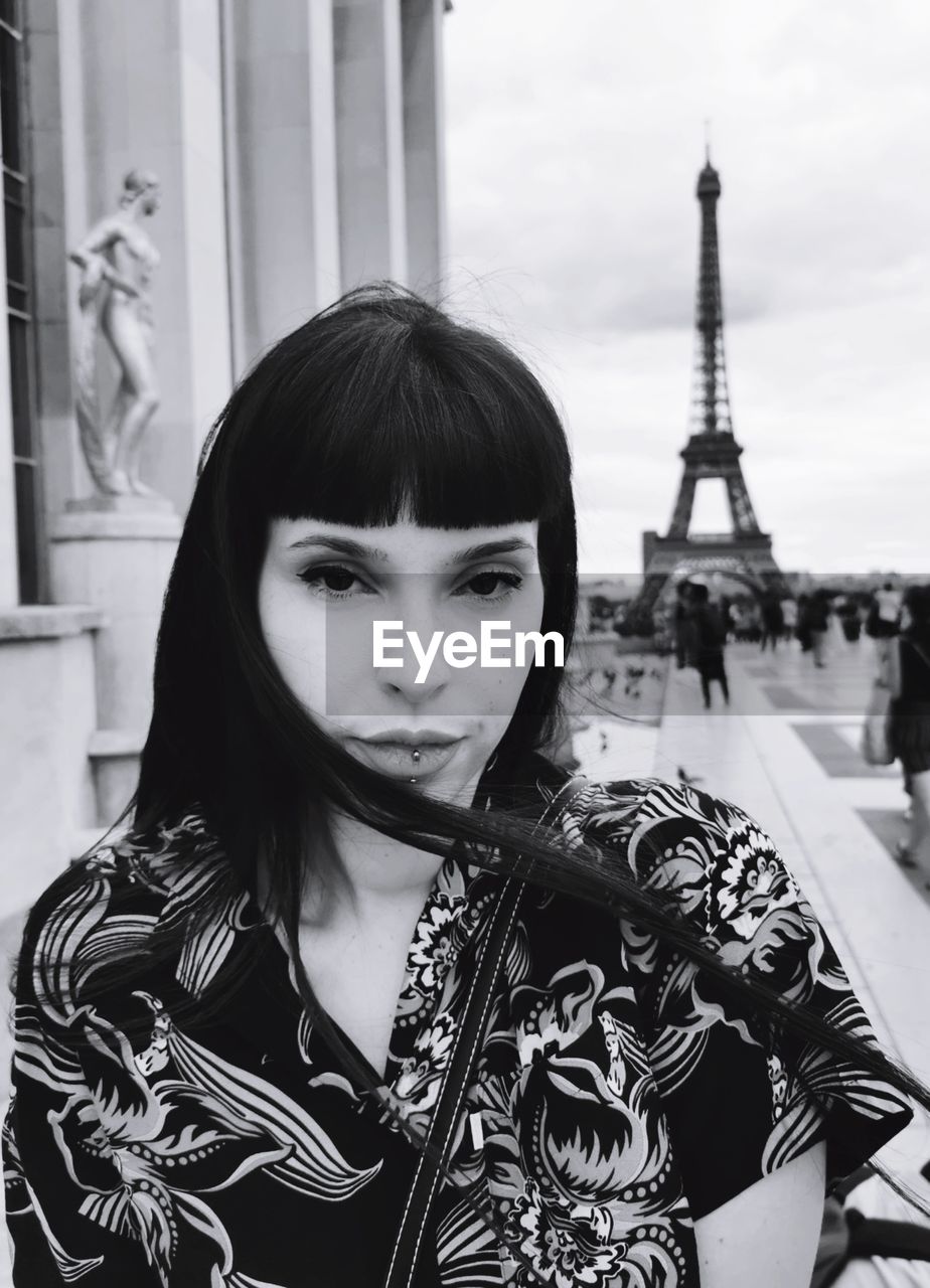 Portrait of woman standing against tour eiffel