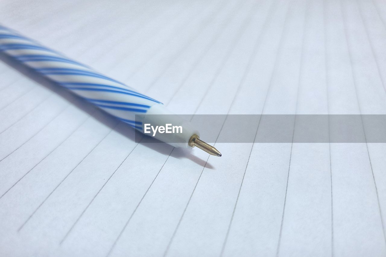 HIGH ANGLE VIEW OF PEN ON WOODEN TABLE