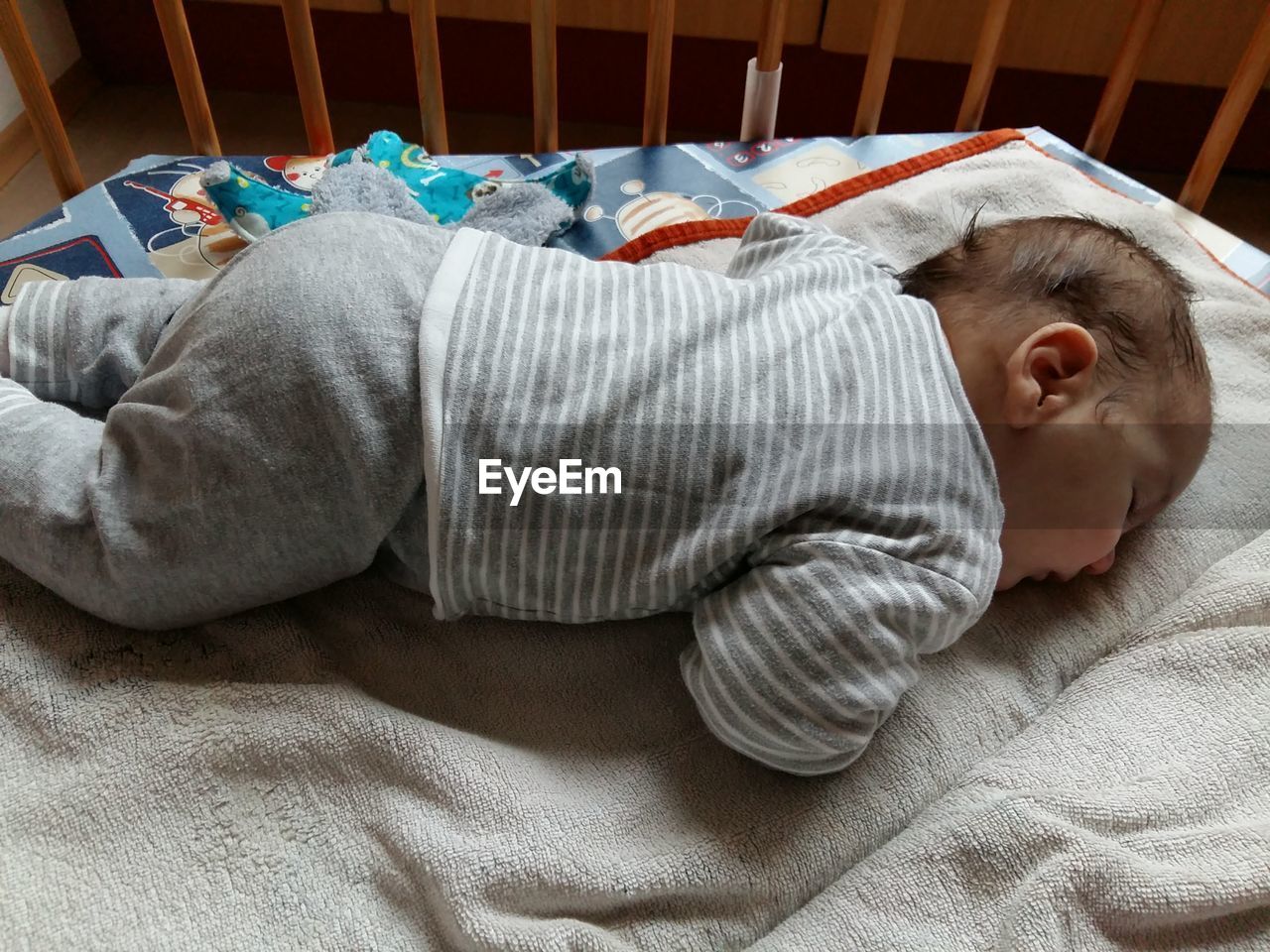 Cute baby boy sleeping on bed