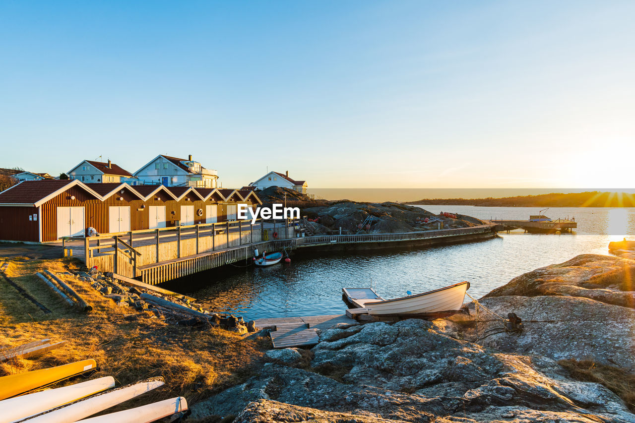 The picture displays a beautiful sunset over the harbor of an old swedish seaside cabins,