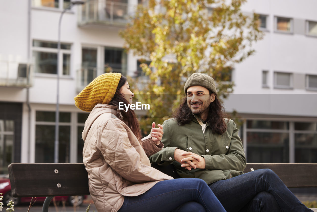 Man and woman talking on bench