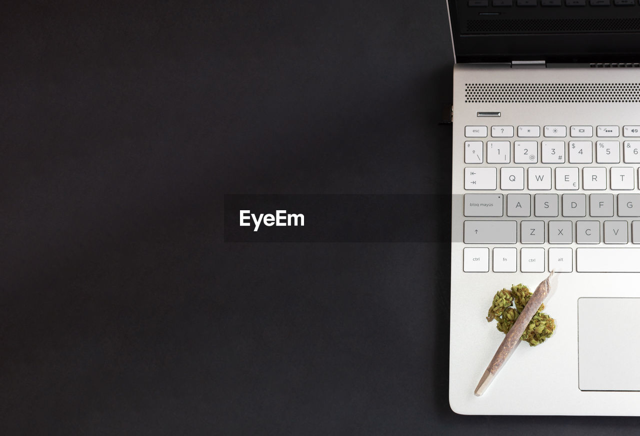 HIGH ANGLE VIEW OF LAPTOP AND TEXT ON TABLE