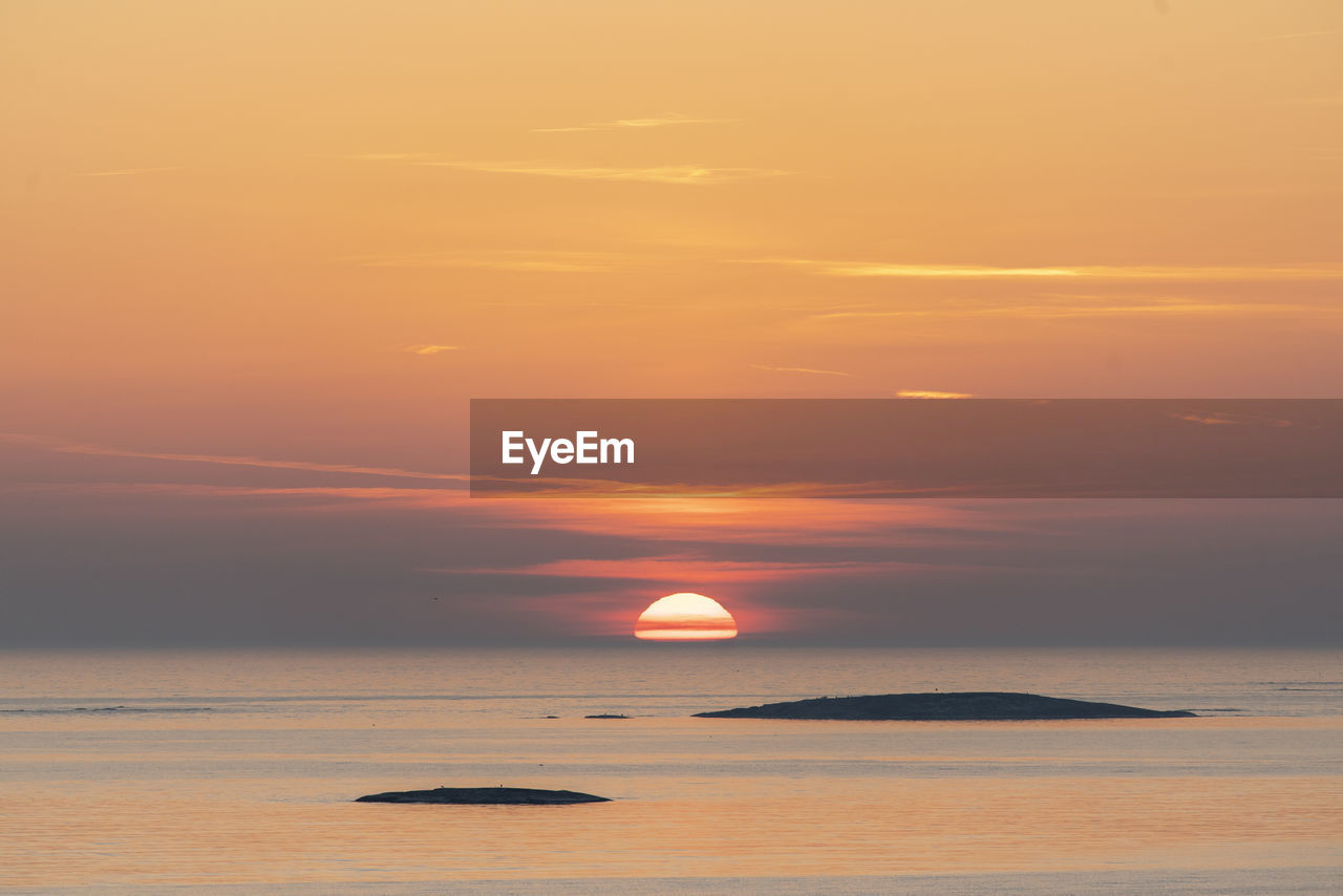 Scenic view of sea against orange sky