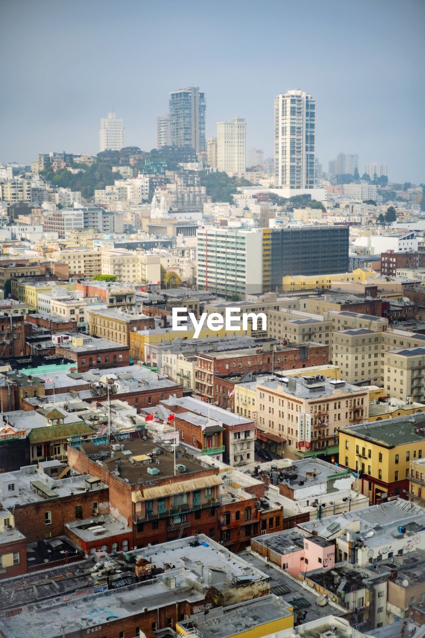 Aerial view of buildings in city against sky