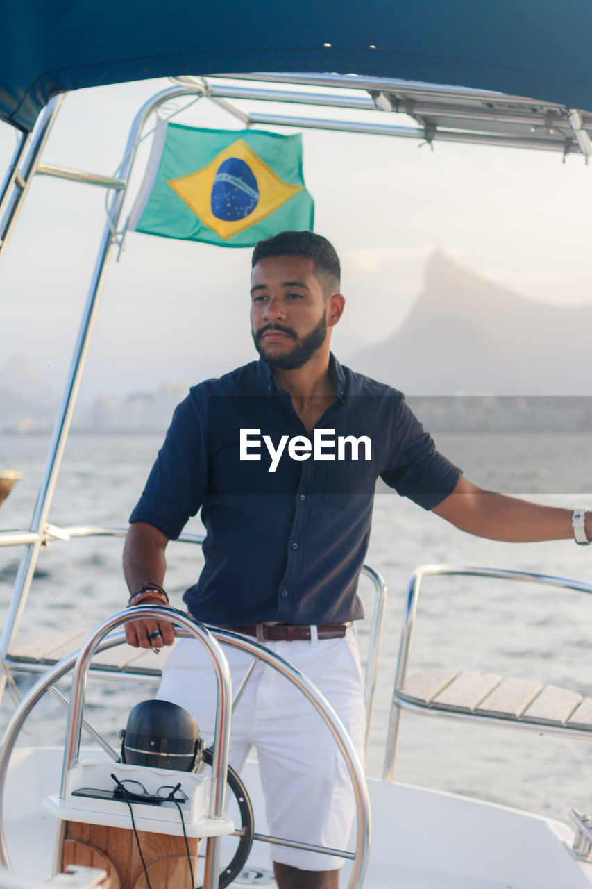 Portrait of young man driving boat in river