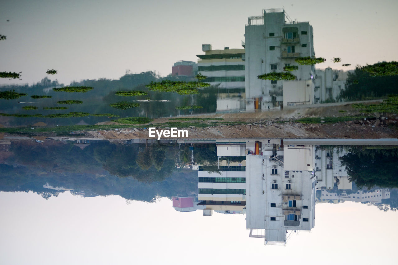 BUILDING BY LAKE AGAINST SKY