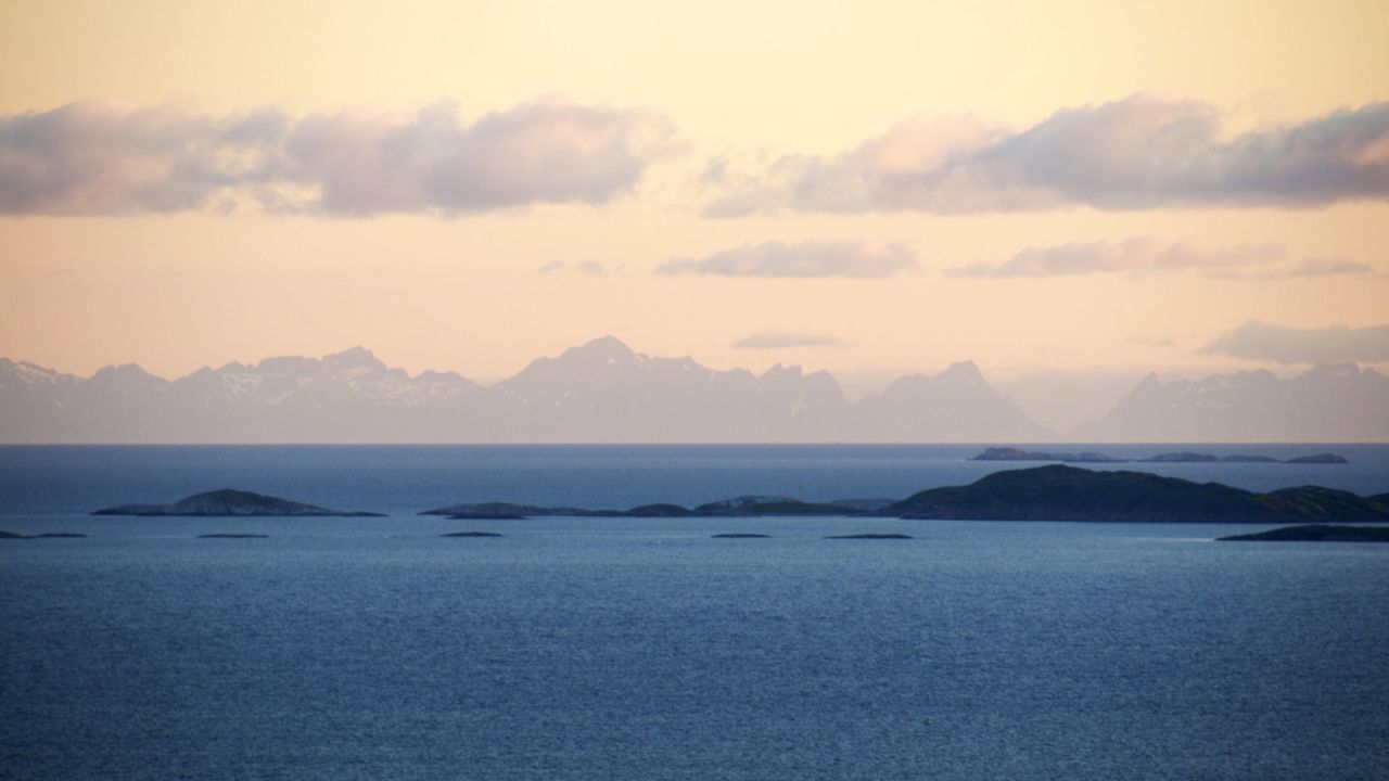 Scenic view of sea and mountains against sky