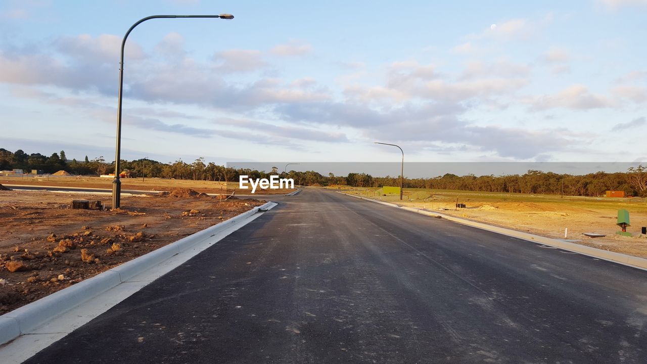 ROAD AMIDST TREES AGAINST SKY