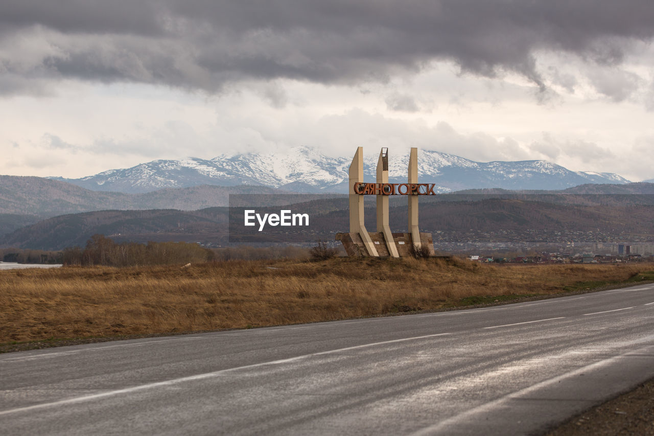 Scenic view of road by mountains against sky