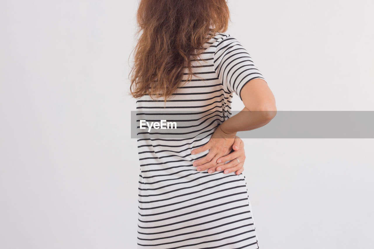 Woman suffering from backache against white background