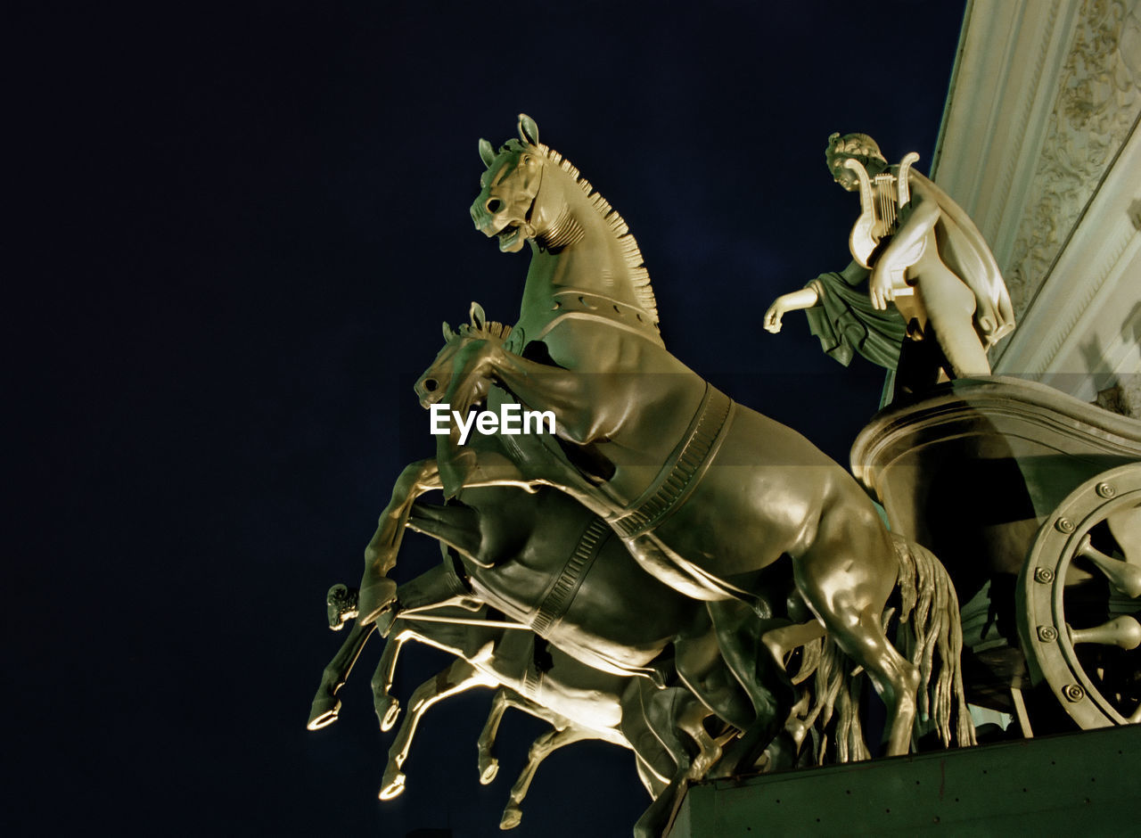 Low angle view of statues at bolshoi theatre at night