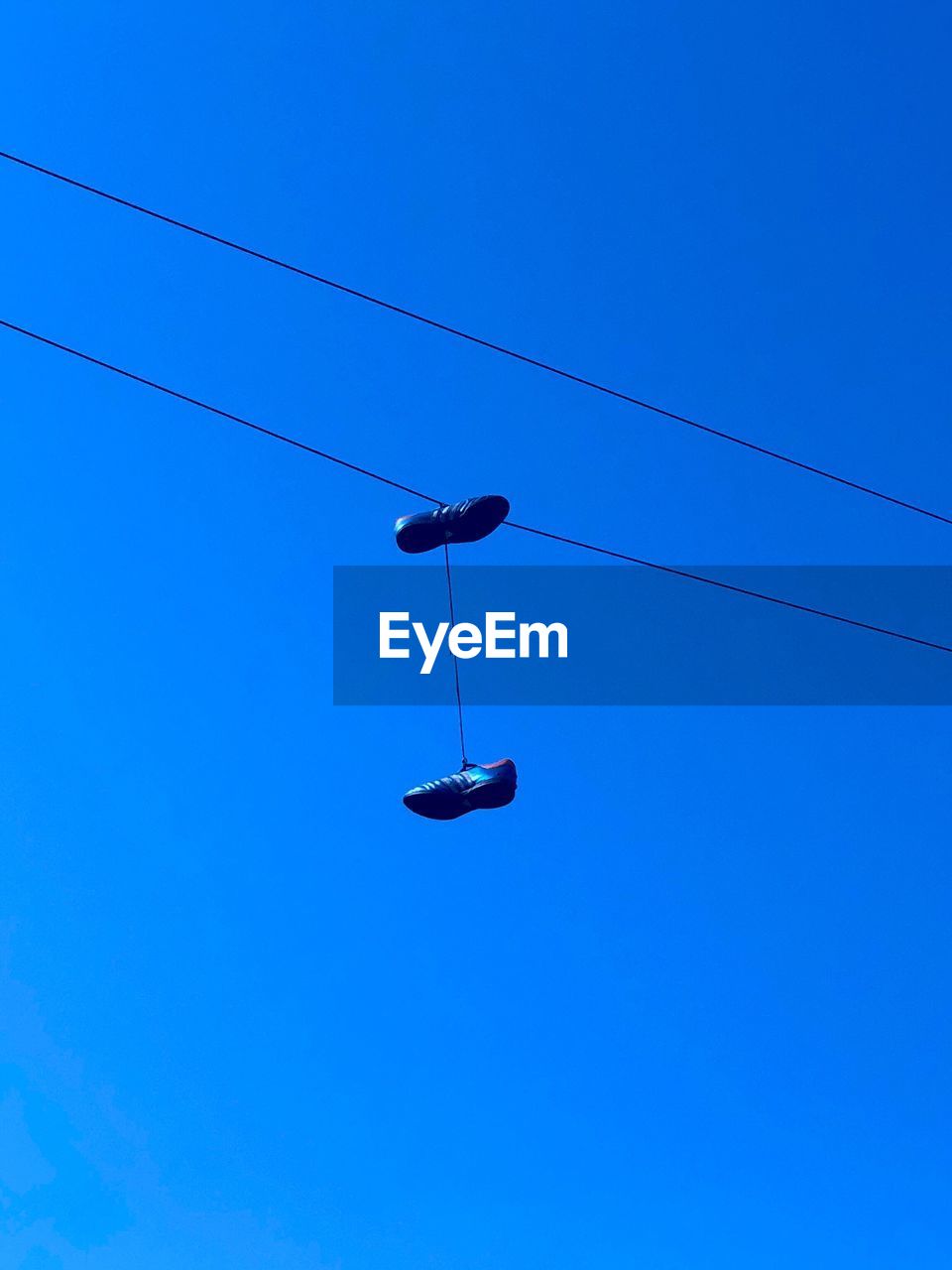 LOW ANGLE VIEW OF POWER LINES AGAINST CLEAR BLUE SKY