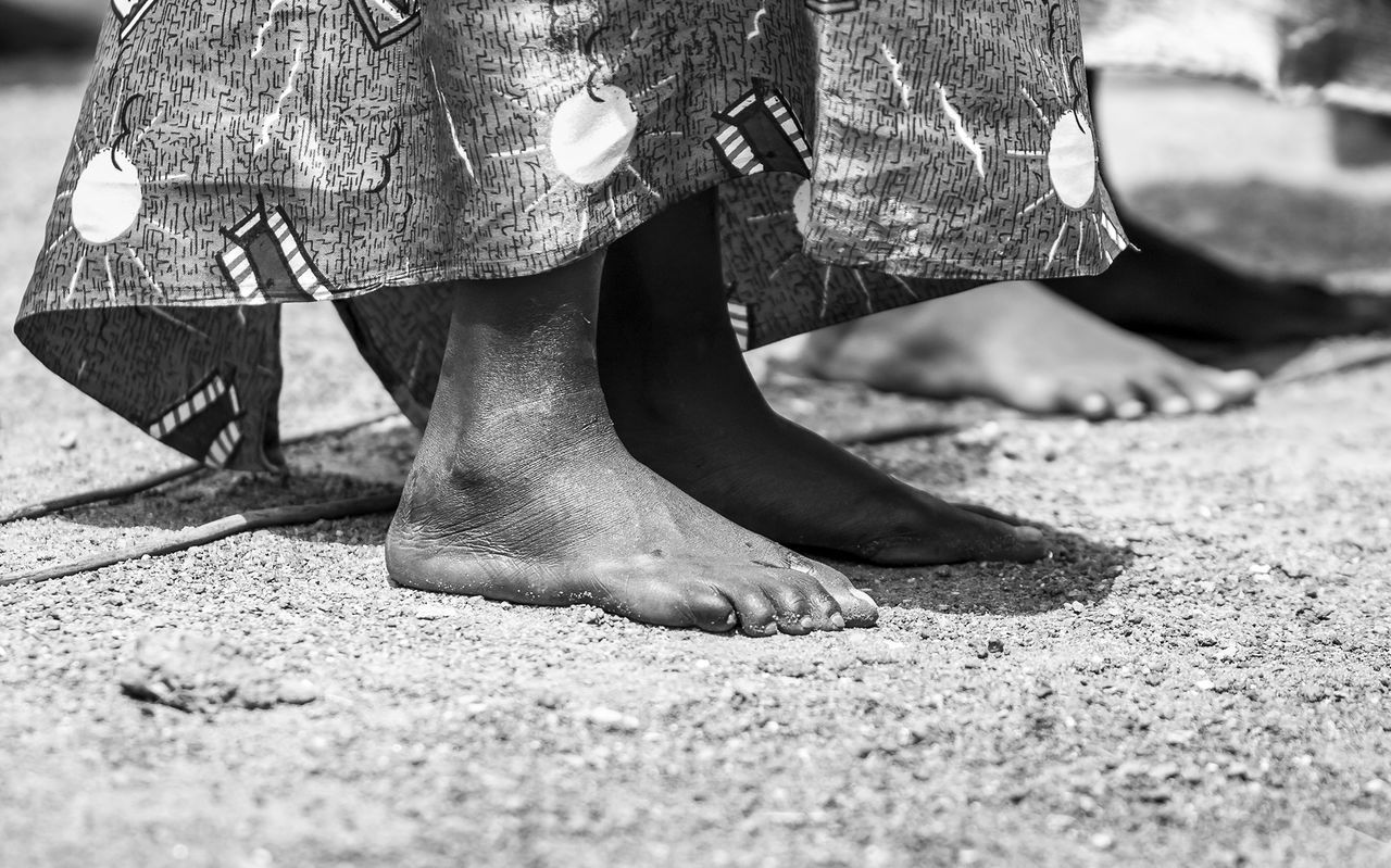 Low section of woman with barefoot standing on ground