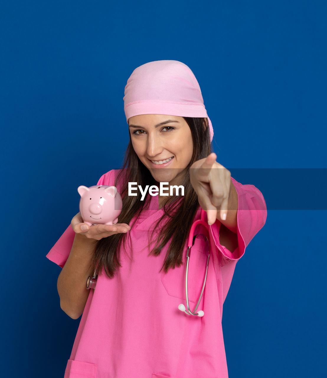 PORTRAIT OF HAPPY WOMAN STANDING AGAINST PINK BLUE SKY