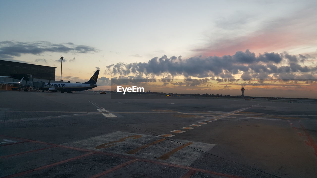 AIRPLANE ON AIRPORT RUNWAY AGAINST SKY