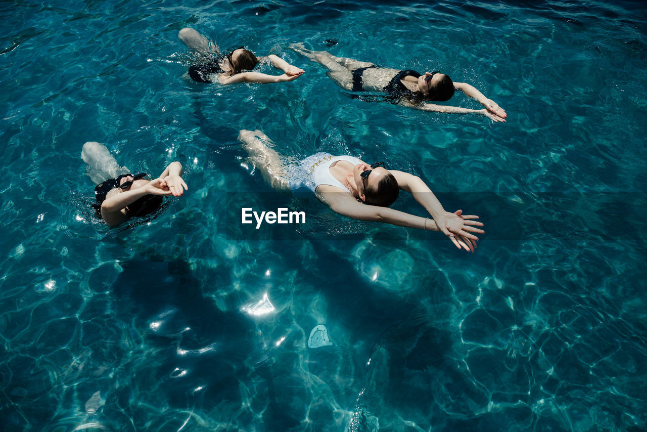 Pool party woman swimming in sync