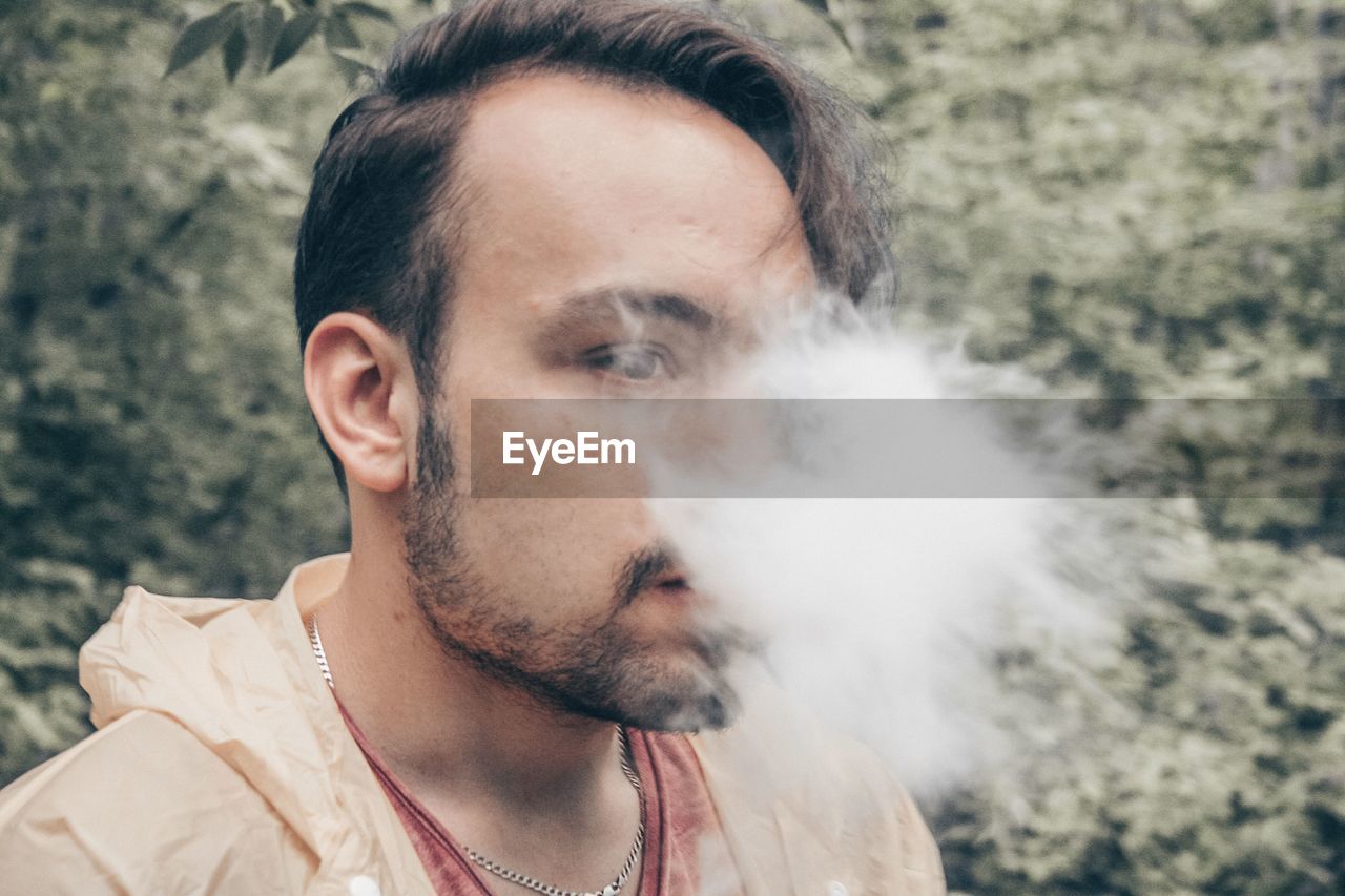 Close-up of young man smoking outdoors