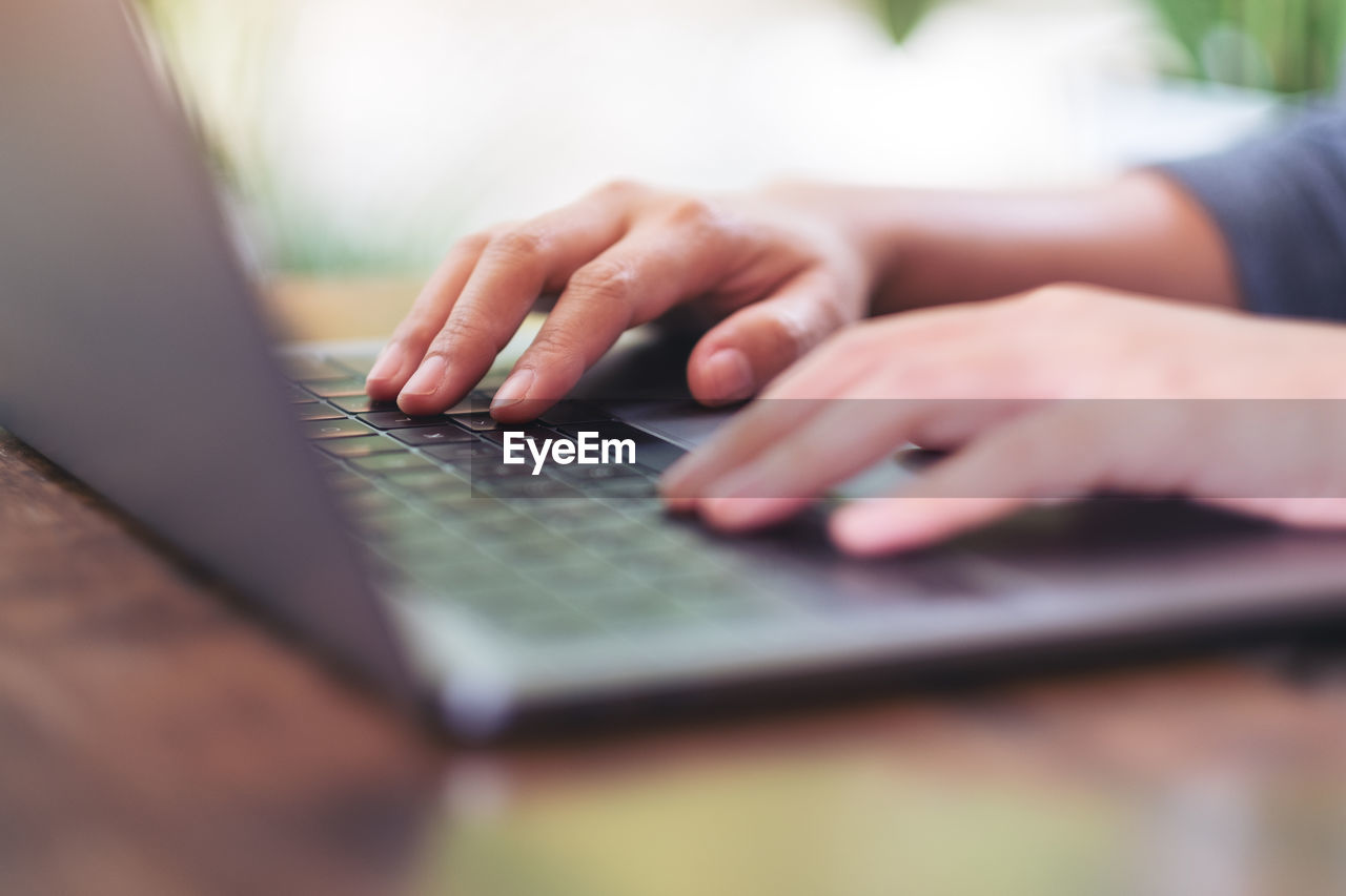 Midsection of man using laptop on table