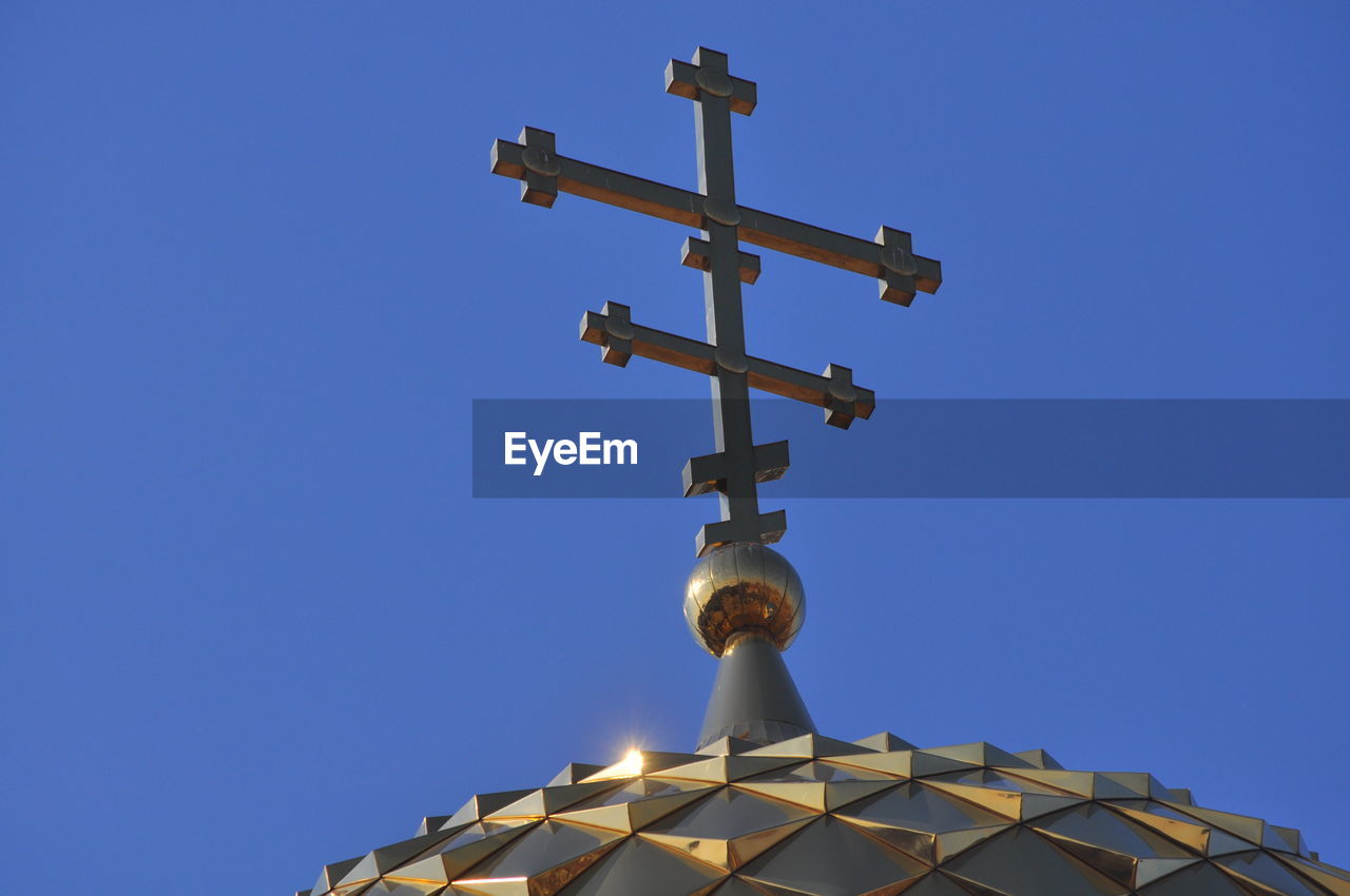 Low angle view of cross against clear blue sky