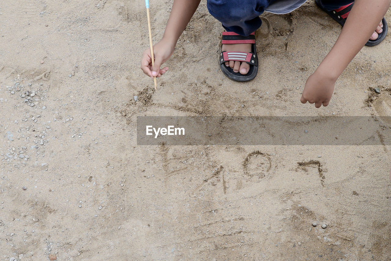 sand, beach, land, low section, childhood, child, leisure activity, human leg, high angle view, day, soil, women, two people, men, lifestyles, nature, trip, vacation, barefoot, shoe, togetherness, holiday, female, casual clothing, outdoors, limb, footwear, floor, human foot, human limb, sandal, clothing, summer, family, footprint