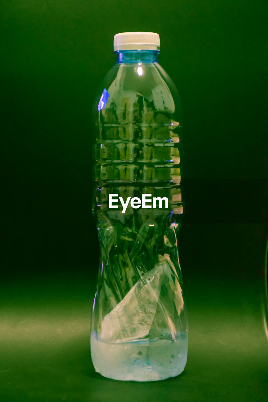 Close-up of water bottle against green background