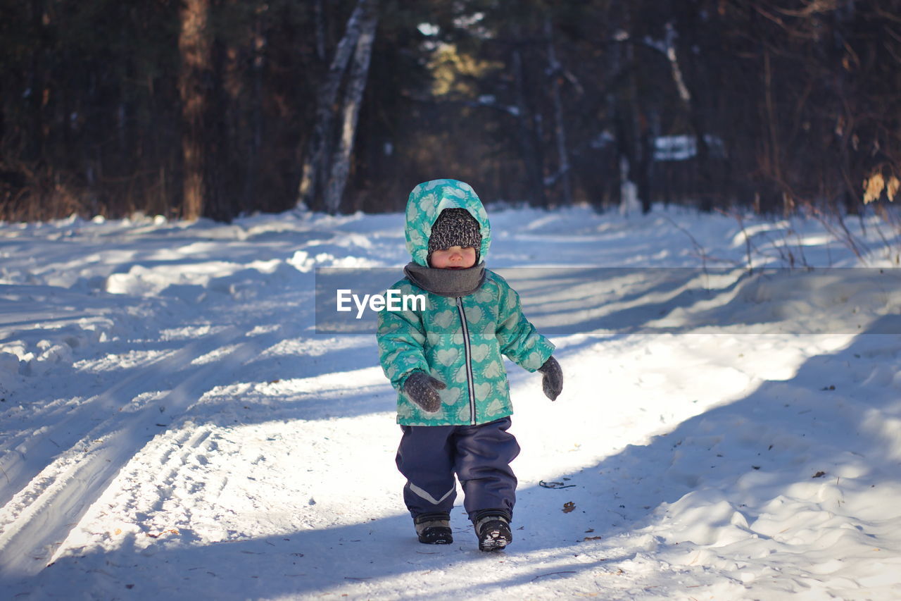 Full length of girl walking on snow covered land