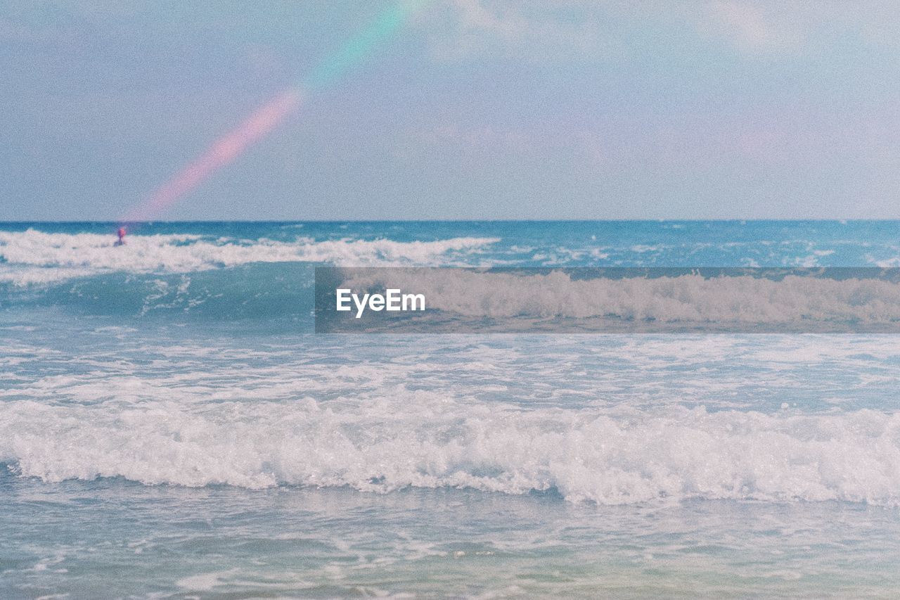 Scenic view of waves in sea against sky