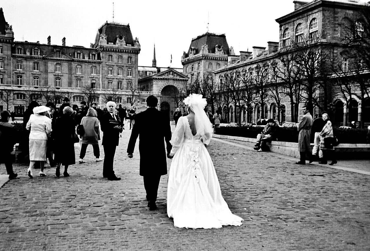 Bride and bridegroom walking on street in city
