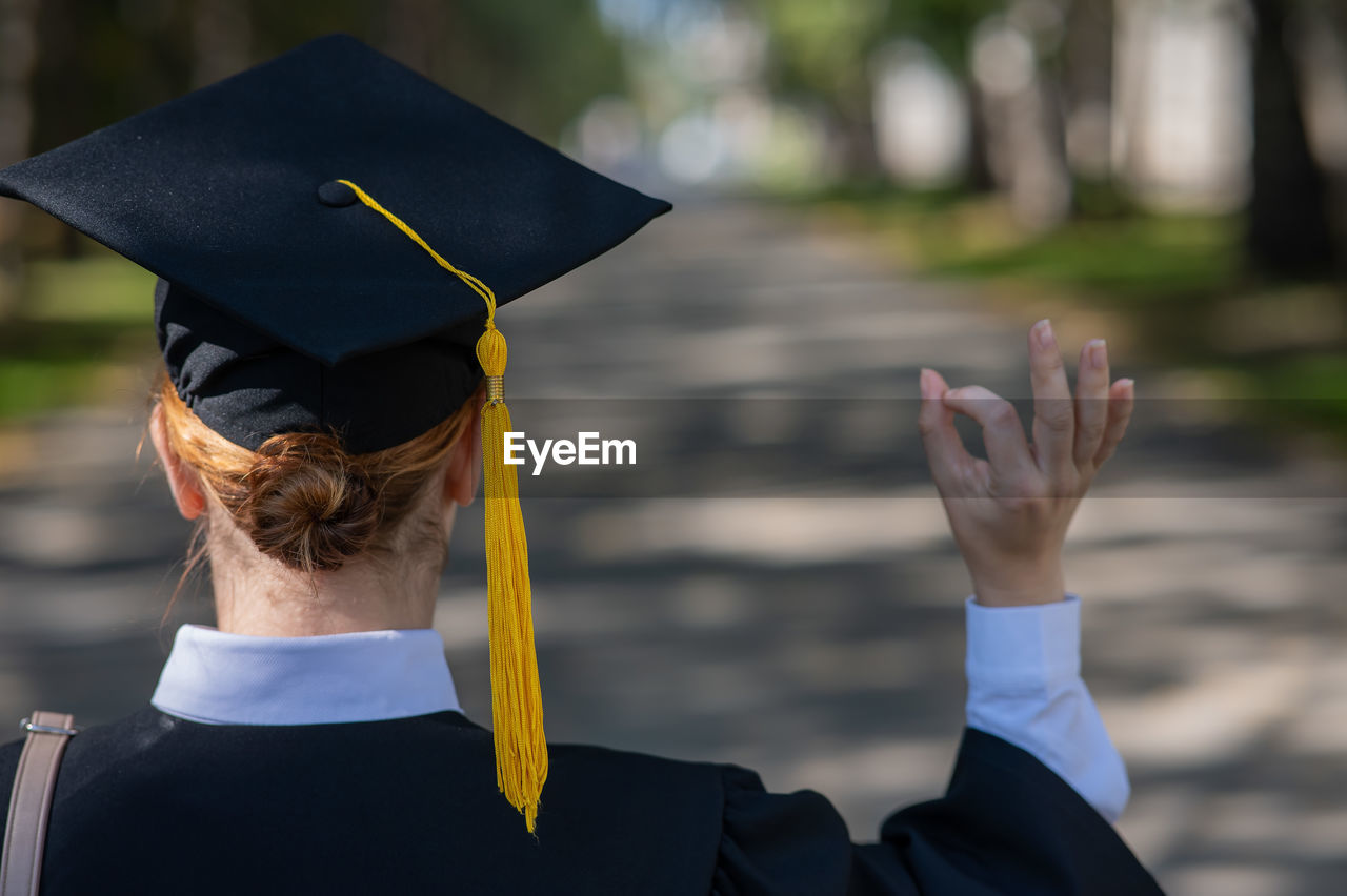 rear view of man wearing graduation gown