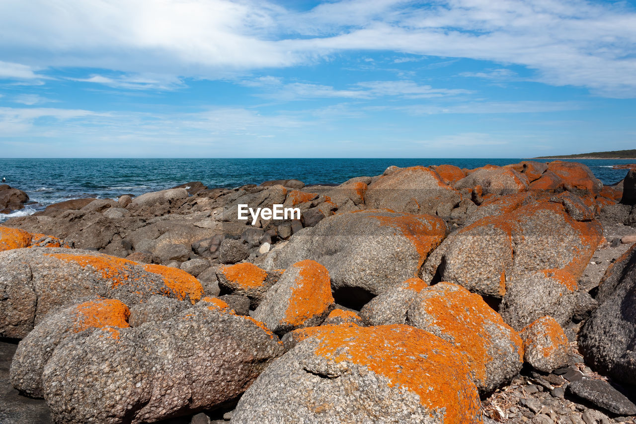 SCENIC VIEW OF ROCKS ON SHORE AGAINST SKY