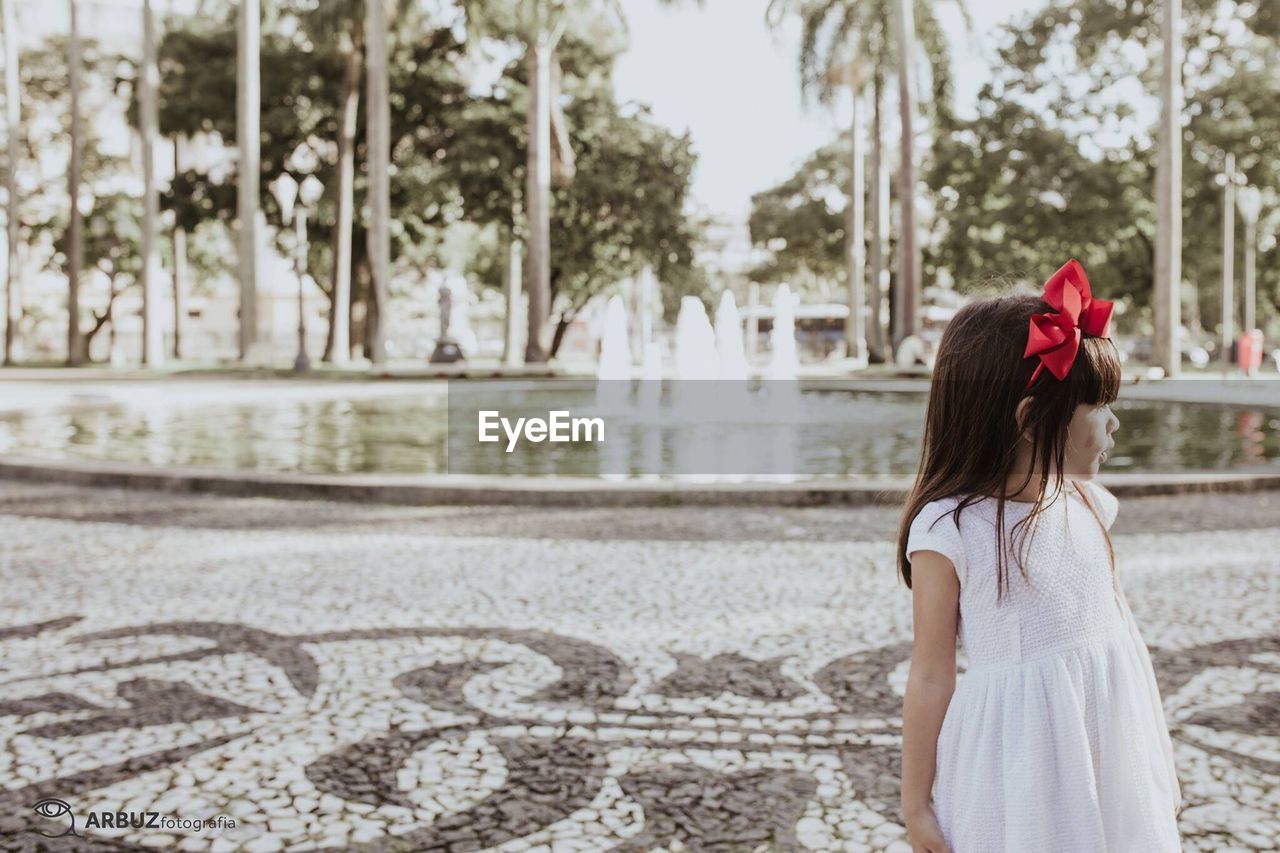 Girl standing against fountain