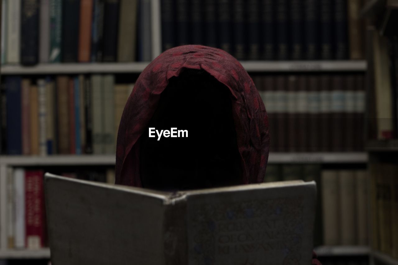 Invisible person reading book in library