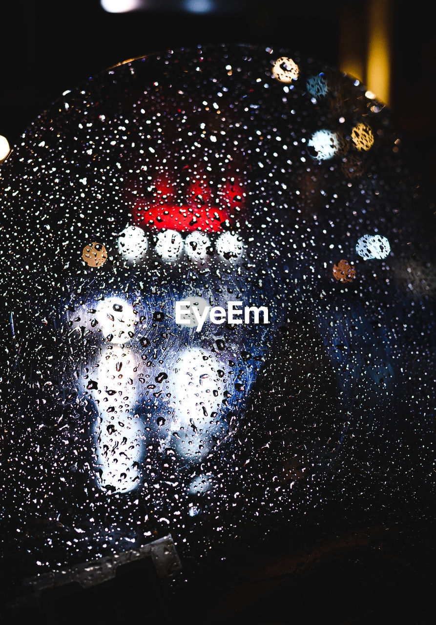 Close-up of wet glass at night